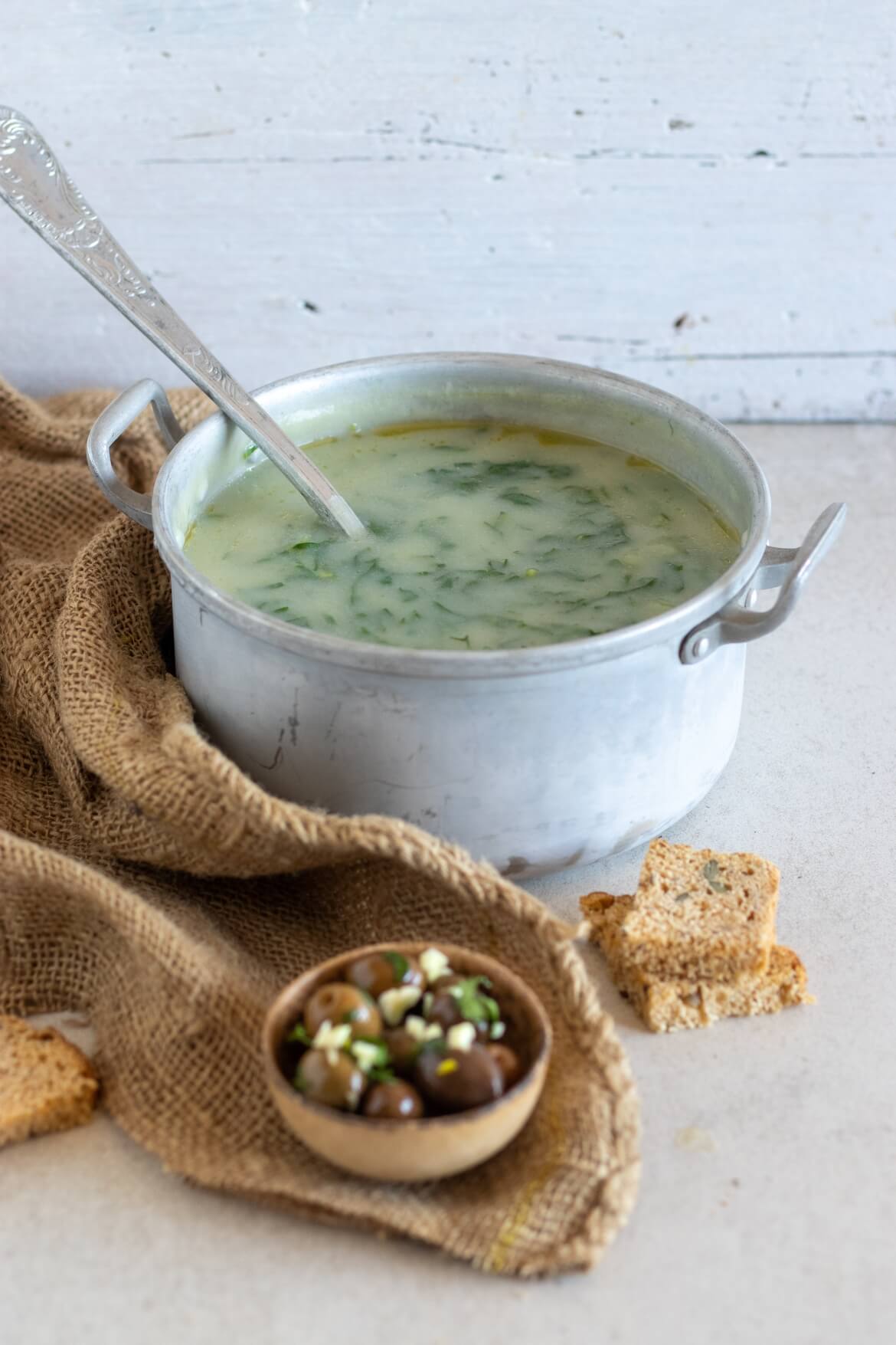 panela com sopa caldo verde e colher de sopa