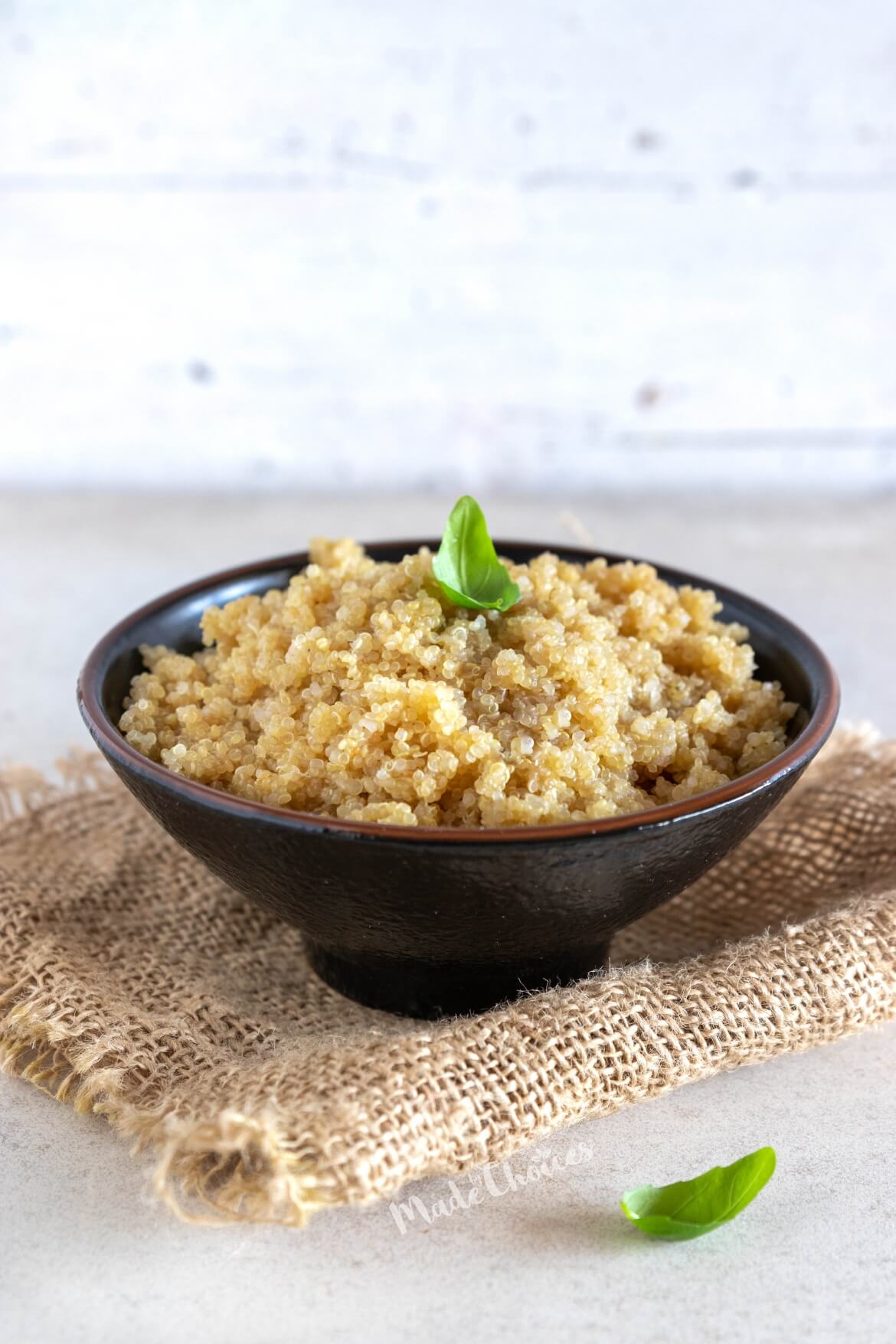 Taça com quinoa cozida e folhas de manjerição