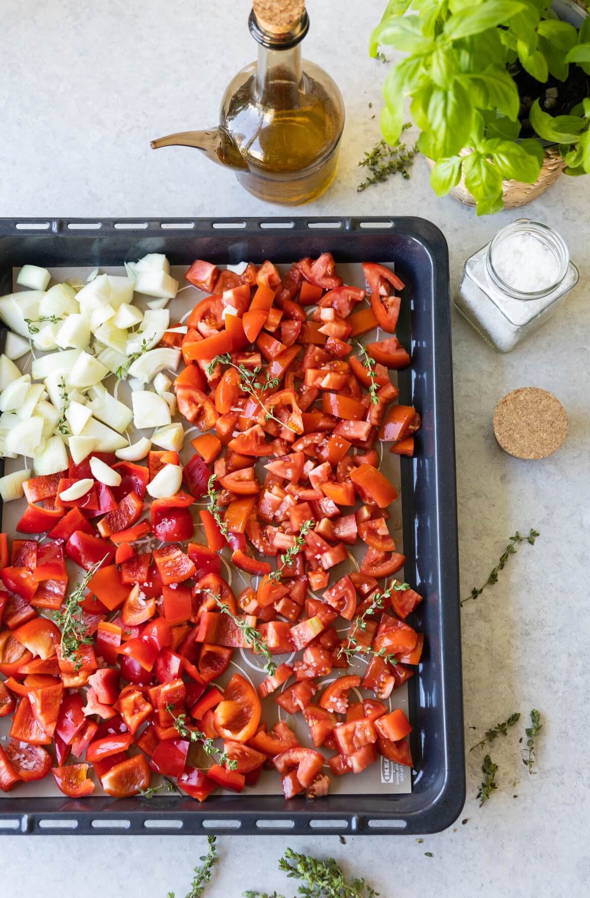 Tabuleiro com tomate, pimentos, cebola e alho cortados prontos para ir ao forno