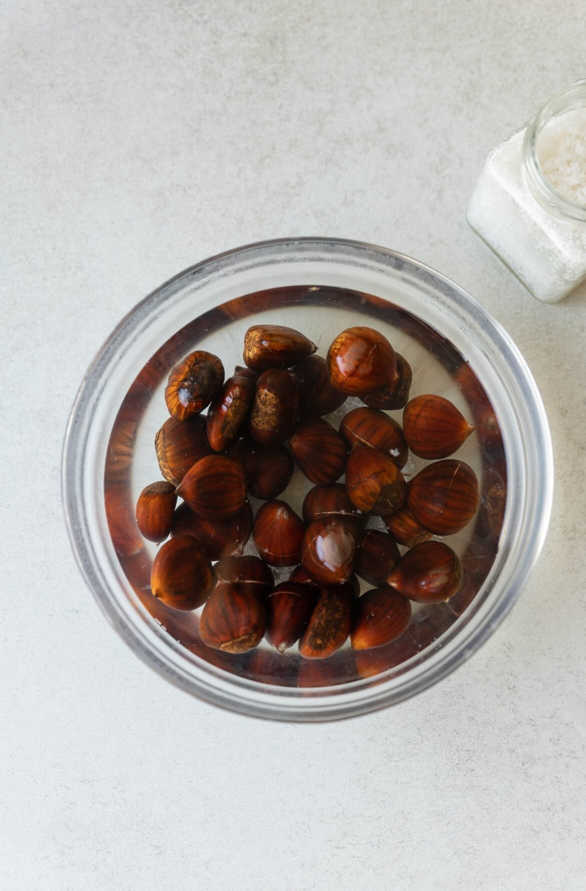 Castanhas com água e sal dentro de uma taça transparente