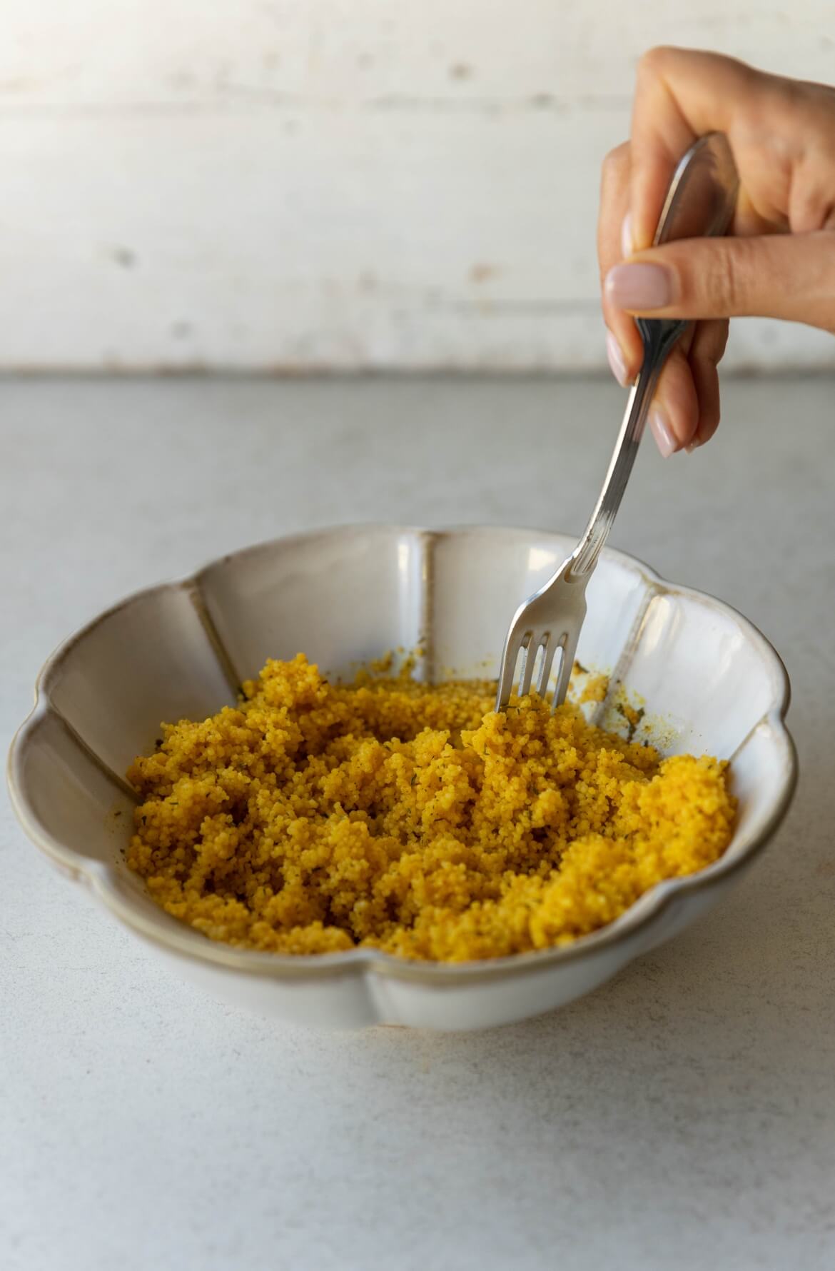 Como cozinhar cuscuz: etapa final em que se solta o cuscuz com um garfo para obter uma textura leve.